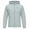 A light grey hooded ideal apparel windbreaker jacket with a full front zipper and a small gray stylized logo on the left chest, displayed on a clean white background.