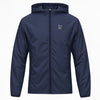 A navy blue hooded ideal apparel windbreaker jacket with a full front zipper and a small light gray stylized logo on the left chest, displayed on a clean white background.